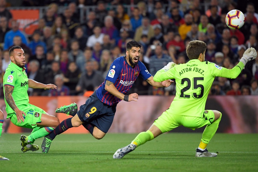 Barcelona's Uruguayan forward Luis Suarez (C) vies with Levante's Spanish goalkeeper Aitor Fernandez during the Spanish League football match between FC Barcelona and Levante UD at the Camp Nou stadium in Barcelona on April 27, 2019. (Photo by LLUIS GENE / AFP)