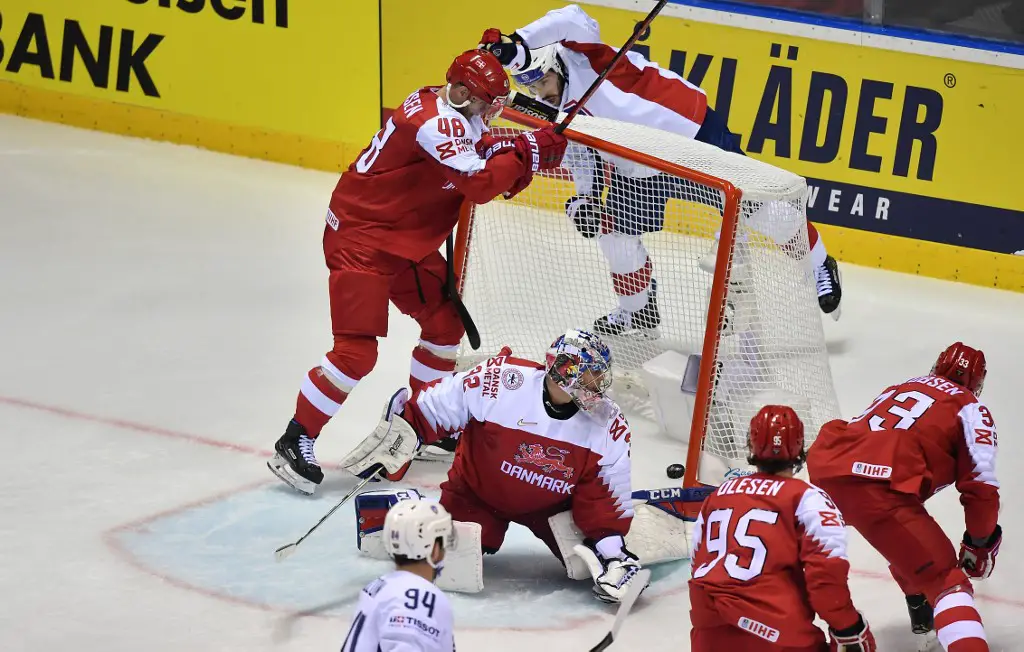 Denmark's goalkeeper Sebastian Dahm (C) looks after the puck as France's players score during the IIHF Men's Ice Hockey World Championships Group A match between Denmark and France on May 11, 2019 in Kosice, Slovakia. (Photo by JOE KLAMAR / AFP)