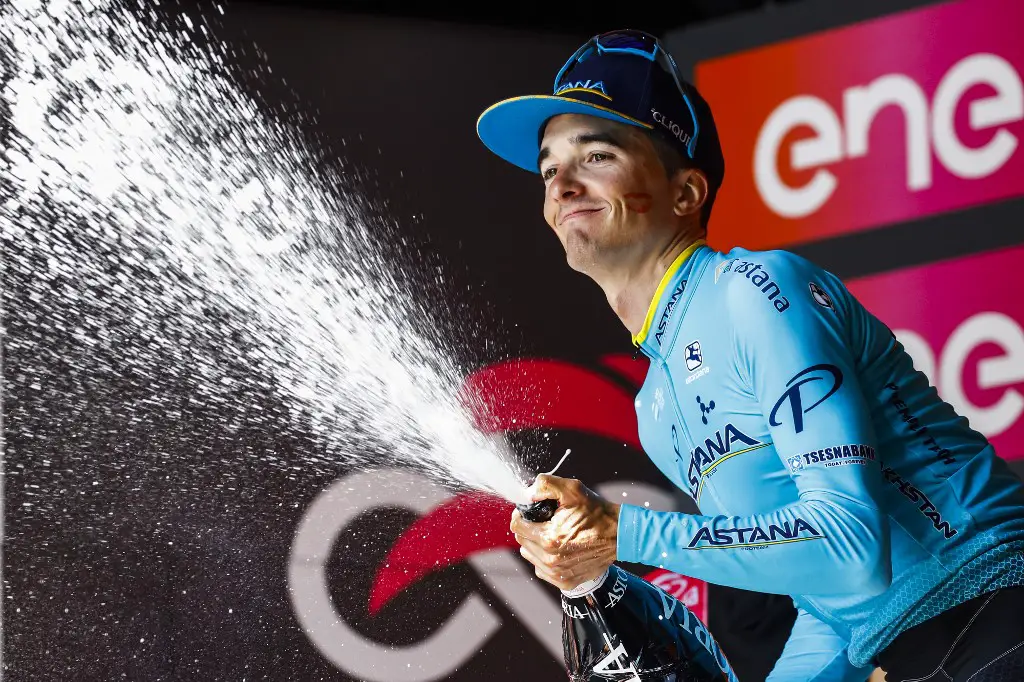 Team Astana rider Spain's Pello Bilbao celebrates on the podium with sparkling wine after winning stage seven of the 102nd Giro d'Italia - Tour of Italy - cycle race, 185kms from Vasto to L'Aquila on May 17, 2019. (Photo by Luk BENIES / AFP)