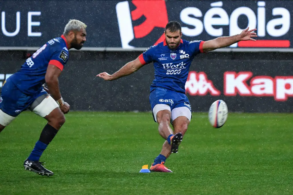 Grenoble's French full back Gaetan Germain (R) hits a penalty kick during the French Top 14 rugby union match between Grenoble (FCG) and Stade Français (SF) on April 6, 2019 at the Stade des Alpes in Grenoble, central-eastern France. (Photo by JEAN-PIERRE CLATOT / AFP)