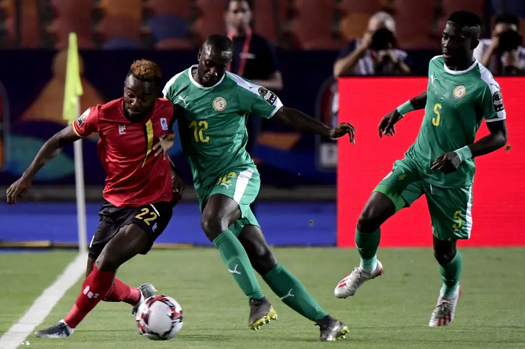 Uganda's forward Lumala Abdu (L) fights for the ball against Senegal's defender Youssouf Sabaly (C) and Senegal's midfielder Idrissa Gueye (R) during the 2019 Africa Cup of Nations (CAN) Round of 16 football match between Uganda and Senegal at the Cairo International Stadium in the Egyptian capital on July 5, 2019. (Photo by JAVIER SORIANO / AFP)