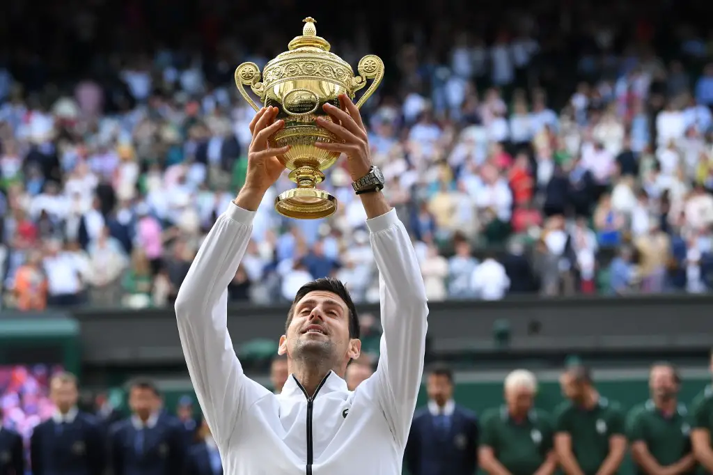 Serbia's Novak Djokovic raises the winner's trophy after beating Switzerland's Roger Federer during their men's singles final on day thirteen of the 2019 Wimbledon Championships at The All England Lawn Tennis Club in Wimbledon, southwest London, on July 14, 2019. (Photo by Ben STANSALL / AFP) / RESTRICTED TO EDITORIAL USE