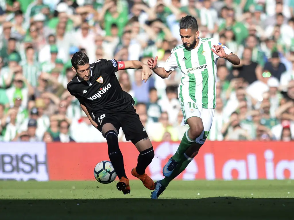 Sevilla's Spanish defender Sergio Escudero (L) vies with Real Betis' Algerian midfielder Ryad Boudebouz during the Spanish league football match between Real Betis and Sevilla at the Benito Villamarin stadium in Sevilla on May 12, 2018. (Photo by CRISTINA QUICLER / AFP)