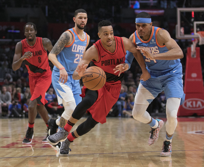 Defenders of the Los Angeles Clippers try to stop CJ McCollum #3 of the Portland Trailblazers
