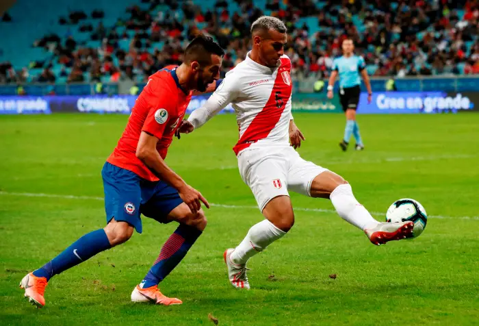 Peru's Miguel Trauco in action with Chile's Mauricio Isla
