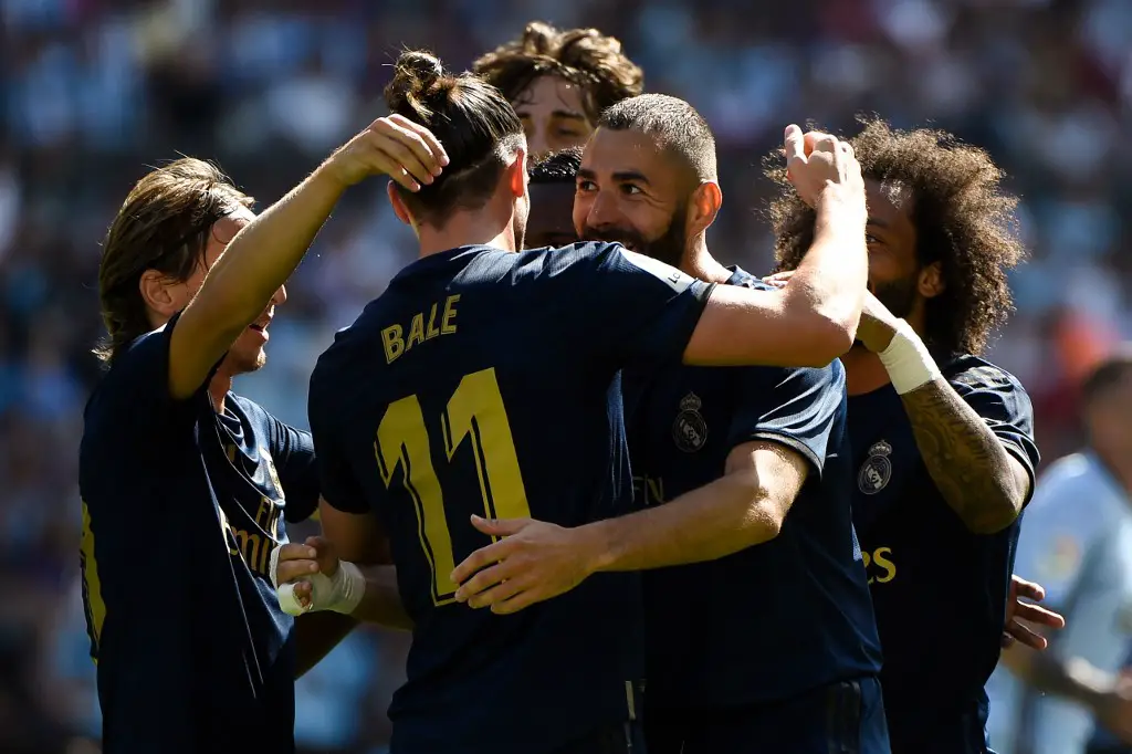 Real Madrid's French forward Karim Benzema (C) celebrates with teammates after scoring a goal during the Spanish League football match between Celta Vigo and Real Madrid at the Balaidos Stadium in Vigo on August 17, 2019. (Photo by MIGUEL RIOPA / AFP)