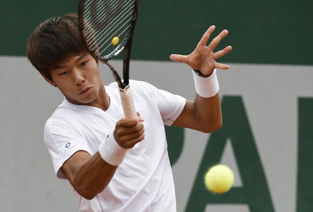 TO GO WITH AFP STORY BY LUDOVIC LUPPINO -South Korea's Lee Duckhee hits a return during his French tennis Open second round match in the category under 18 at the Roland Garros stadium in Paris on June 4, 2014. AFP PHOTO / PASCAL GUYOT (Photo by PASCAL GUYOT / AFP)