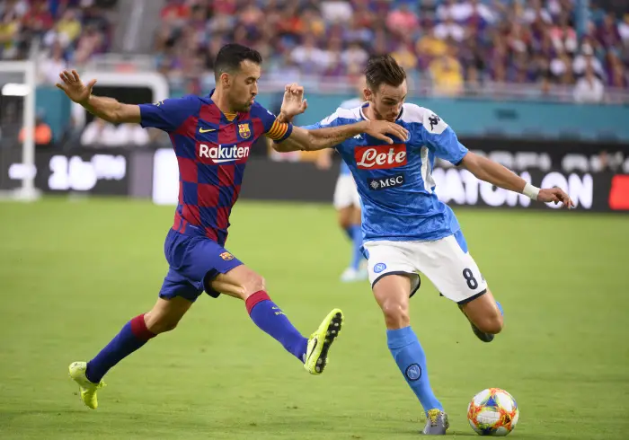 MIAMI GARDENS, FL - AUGUST 07: Napoli's Fabien Ruiz kicks the ball with Barcelona's Sergio Busquets during a International friendly soccer game between FC Barcelona and SSC Napoli on August 7, 2019 at the Hard Rock Stadium in Miami Gardens, Florida.