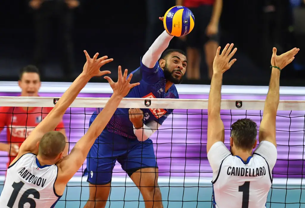France's Earvin Ngapeth (C) plays a shot in front of Italy's Oleg Antonov (L) and Italy's Davide Candellaro (R) during the Euro 2019 volleyball match betwwen France and Italy on September 18, 2019 in Montpellier. (Photo by PASCAL GUYOT / AFP)