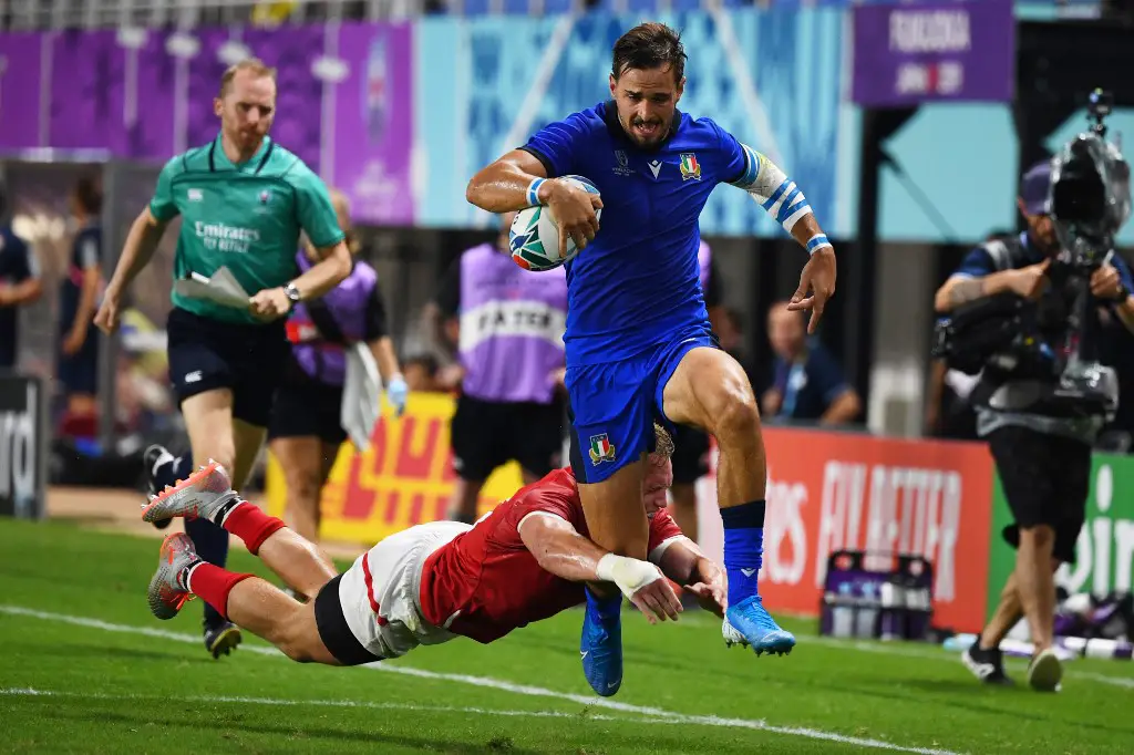 Italy's wing Mattia Bellini (R) evades Canada's centre Ben Lesage (down) and  scores a try  during the Japan 2019 Rugby World Cup Pool B match between Italy and Canada at the Fukuoka Hakatanomori Stadium in Fukuoka on September 26, 2019. (Photo by GABRIEL BOUYS / AFP)