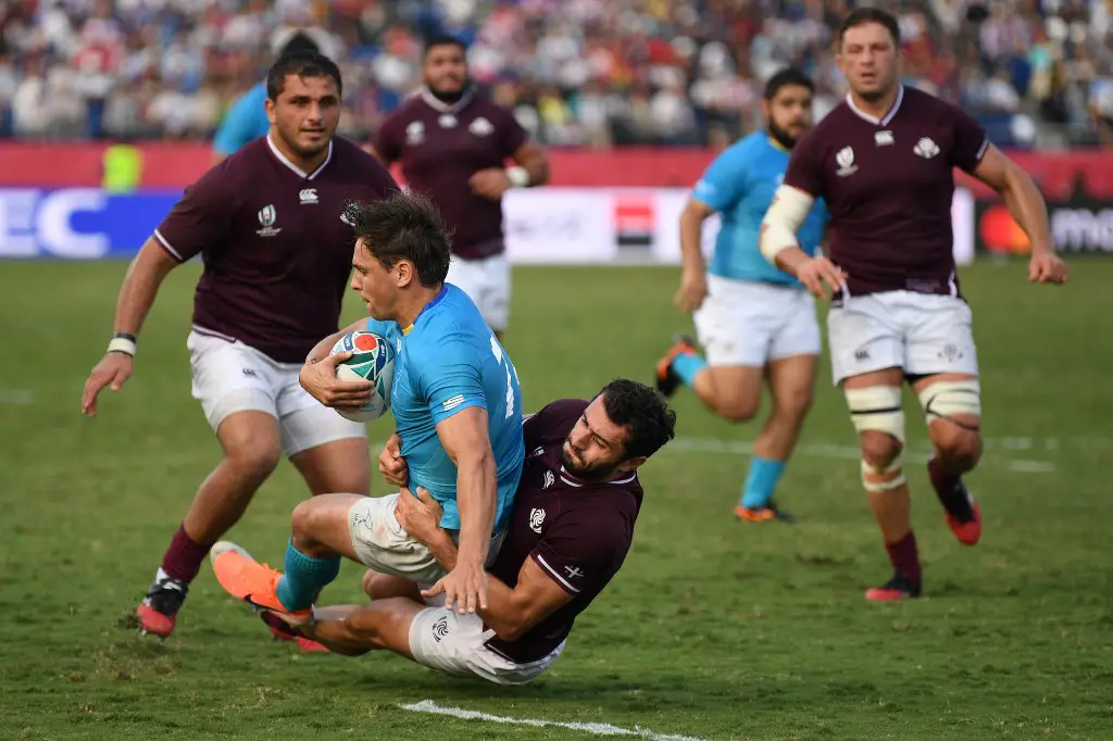 Uruguay's wing Nicolas Freitas (2L0 is tackled by Georgia's wing Zura Dzneladze (C) during the Japan 2019 Rugby World Cup Pool D match between Georgia and Uruguay at the Kumagaya Rugby Stadium in Kumagaya on September 29, 2019. (Photo by CHARLY TRIBALLEAU / AFP)