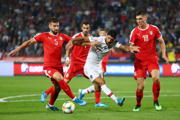Portugal's Goncalo GuedeHin actHn with Serbia's Matija Nastasic and Nikola Milenkovic