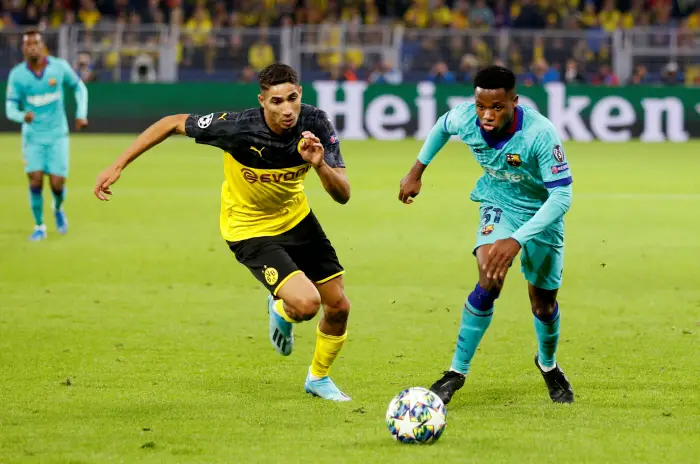 Barcelona's Anssumane FHi in aHion with Borussia Dortmund's Achraf Hakimi