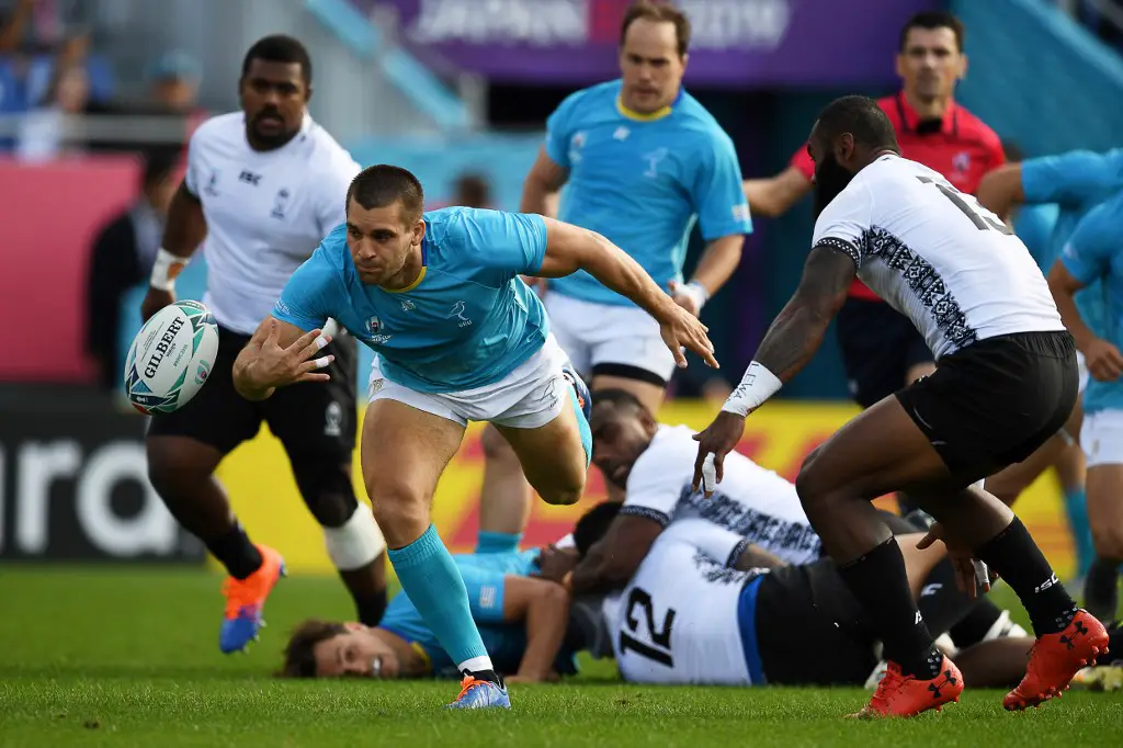 Uruguay's centre Andres Vilaseca (L) reaches for the ball  during the Japan 2019 Rugby World Cup Pool D match between Fiji and Uruguay at the Kamaishi Recovery Memorial Stadium in Kamaishi on September 25, 2019. (Photo by CHARLY TRIBALLEAU / AFP)