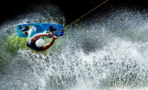 A man jumps with his wakeboard at the water ski facility at the Blauer See in Garbsen on August 5, 2018. (Photo by Peter Steffen / dpa / AFP) / Germany OUT