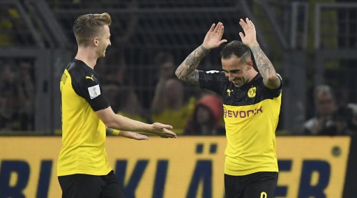 Dortmund's Spanish forward Paco Alcacer (R) celebrates scoring the opening goal with his teammate German forward Marco Reus during the German Supercup foorball match BVB Borussia Dortmund v FC Bayern Munich on August 3, 2019 at the Signal Iduna Park in Dortmund, western Germany. (Photo by INA FASSBENDER / AFP) / DFL REGULATIONS PROHIBIT ANY USE OF PHOTOGRAPHS AS IMAGE SEQUENCES AND/OR QUASI-VIDEO