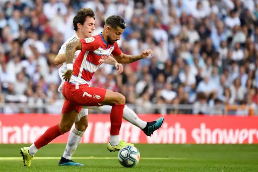 Real Madrid's Spanish defender Alvaro Odriozola (L) vies with Granada's Spanish midfielder Alvaro Vadillo during the Spanish league football match between Real Madrid CF and Granada FC at the Santiago Bernabeu stadium in Madrid on October 5, 2019. (Photo by PIERRE-PHILIPPE MARCOU / AFP)