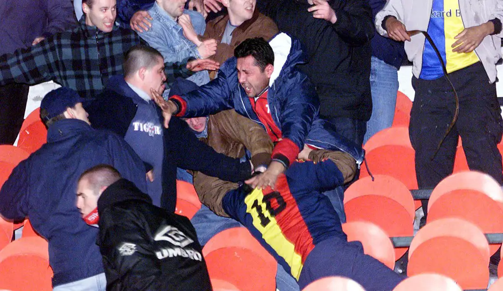 des supporters se battent, le 13 mars 2001 dans les tribunes du Parc des Princes à Paris, lors de la rencontre PSG/Galataray comptant pour la sixième et dernière journée de la deuxième phase de la Ligue des champions de football (Groupe B). Le match a été interrompu après qu'un supporter ait tenté de pénétrer sur la pelouse du stade. Suite aux violentes bagarres observées dans les tribunes, cinq supporters ont été admis à l'hôpital. AFP PHOTO JACK GUEZ 

Paris Saint-Germain and Galatasaray soccer supporters fight in the stands of the Parc des Princes stadium, 13 March 2001 in Paris during the European Champions League match PSG/Galatasaray. The group B match was interrupted after 59 minutes when two members of the crowd, one with a cut face, came onto the pitch. AFP PHOTO JACK GUEZ 
AFP (Photo by JACK GUEZ / AFP)