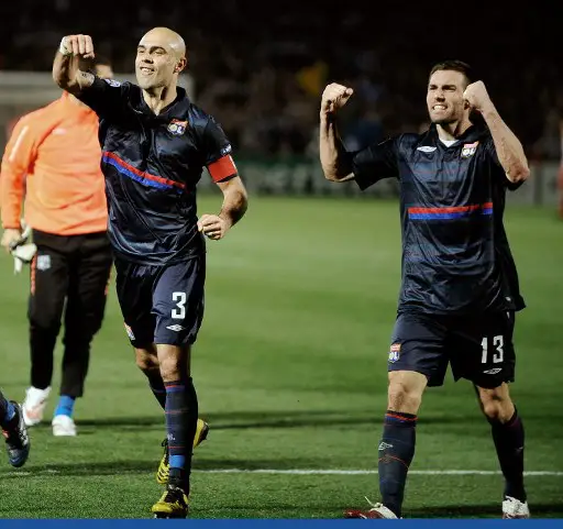 Lyon's defender and captain Cris (L) and defender Anthony Reveillere celebrate after winning the Champions League quarter-final football match against Bordeaux at the Chaban-Delmas stadium, in Bordeaux, western France, on April 7, 2010. AFP PHOTO / JEAN-PIERRE MULLER (Photo by JEAN-PIERRE MULLER / AFP)