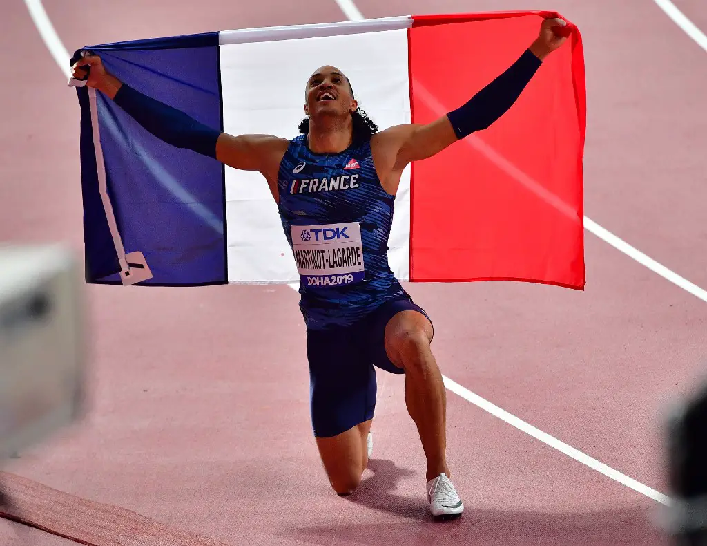France's Pascal Martinot-Lagarde celebrates with the national flag after finishing third in the Men's 110 Hurdles final at the 2019 IAAF Athletics World Championships at the Khalifa International stadium in Doha on October 2, 2019. (Photo by Giuseppe CACACE / AFP)