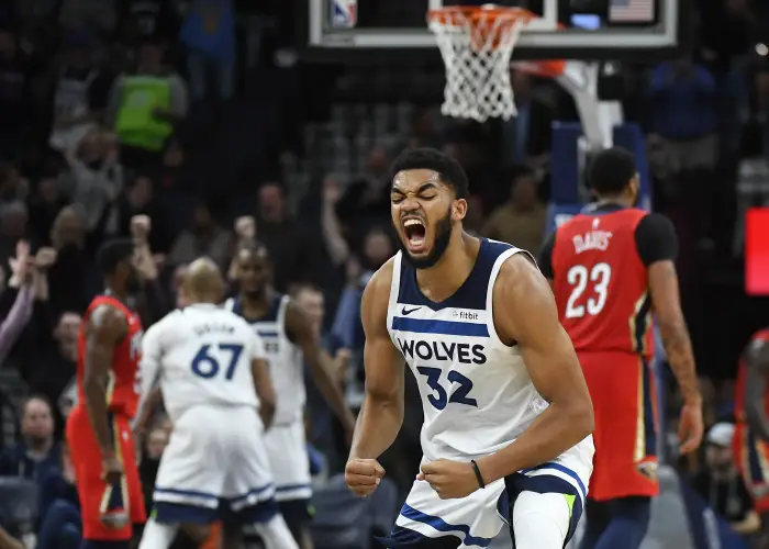 The Minnesota Timberwolves' Karl-Anthony Towns (32) celebrates a fourth-quarter dunk by teammate Andrew Wiggins,