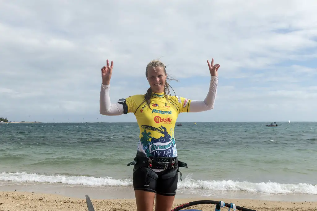 French windsurfer Delphine Cousin flashes the "V for victory" sign on the beach after winning the Noumea Dream Cup women's competition and the 2014 World Champions Women's Slalom tital after competing in the 2014 Windsurfing World Cup on Anse Vata beach in the French South Pacific city of Noumea, in New-Caledonia, on November 23, 2014. French windsurfer Antoine Albeau won his 22nd world windsurfing champion title, confirming his supremacy in the slalom category after a tight duel to the end with French windsurfer Cyril Moussilmani. AFP PHOTO / FRED PAYET (Photo by Fred PAYET / AFP)