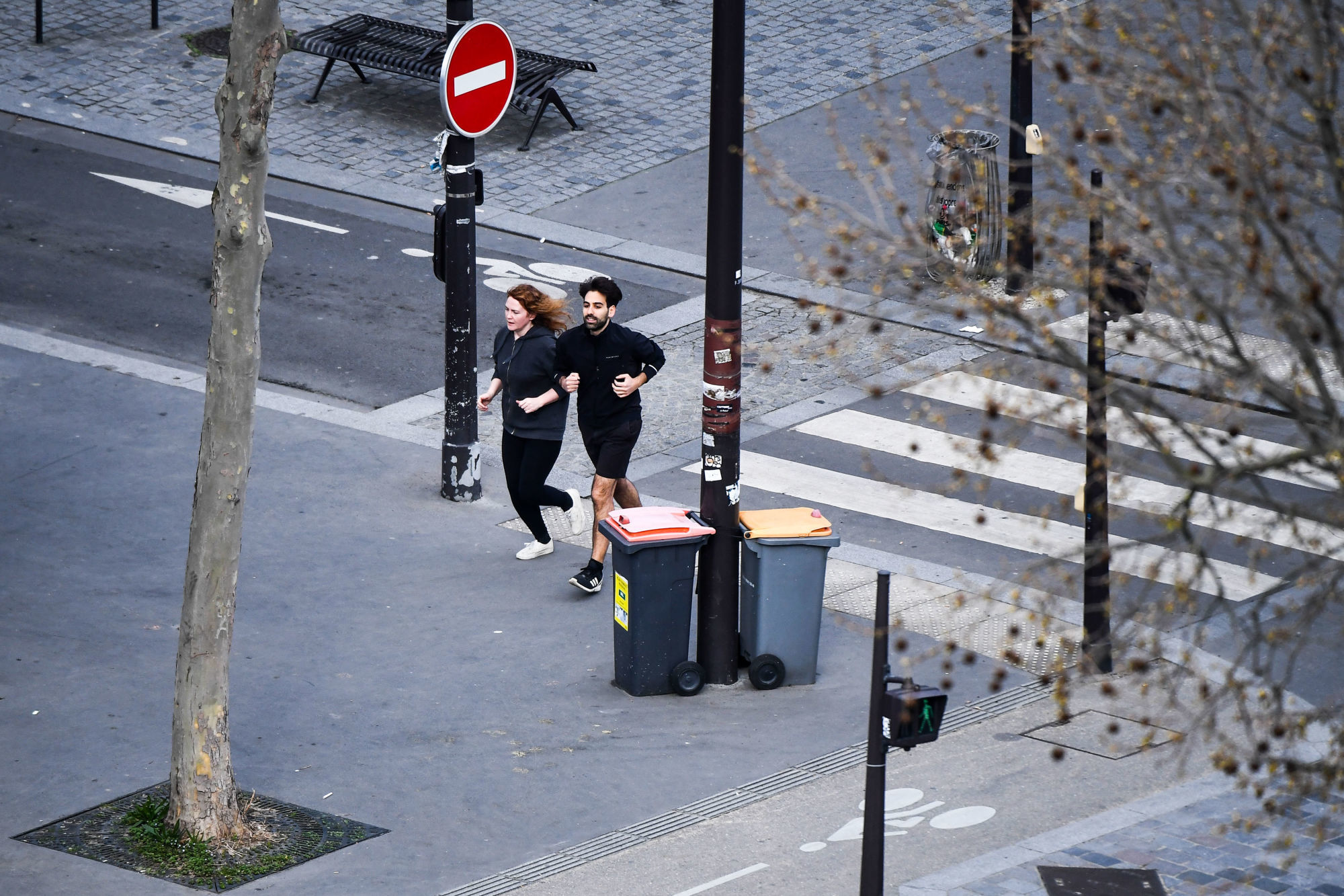 A man and woman running in the street . People of the city came out of their houses to enjoy and play sports on March 18, 2020 in Paris, France. (Photo by Anthony Dibon/Icon Sport) - --- - Paris (France)