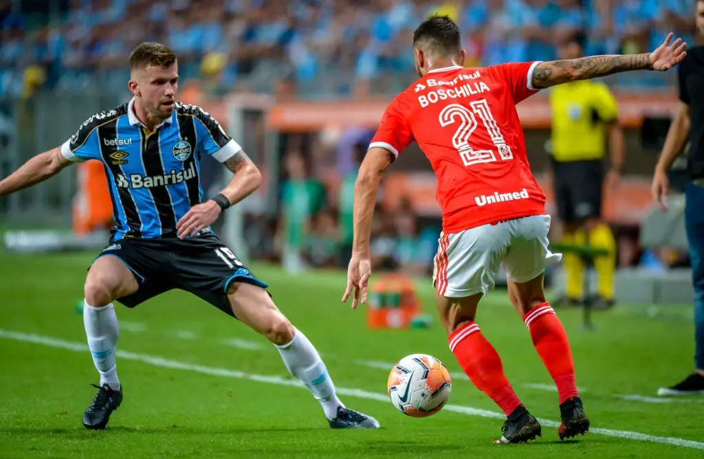 Brazil's Internacional Gabriel Boschilia (R) vies for the ball with Brazil's Gremio Caio Henrique (L) during their 2020 Copa Libertadores match at the Arena do Gremio, in Porto Alegre, Brazil, on March 12, 2020. (Photo by SILVIO AVILA / AFP)