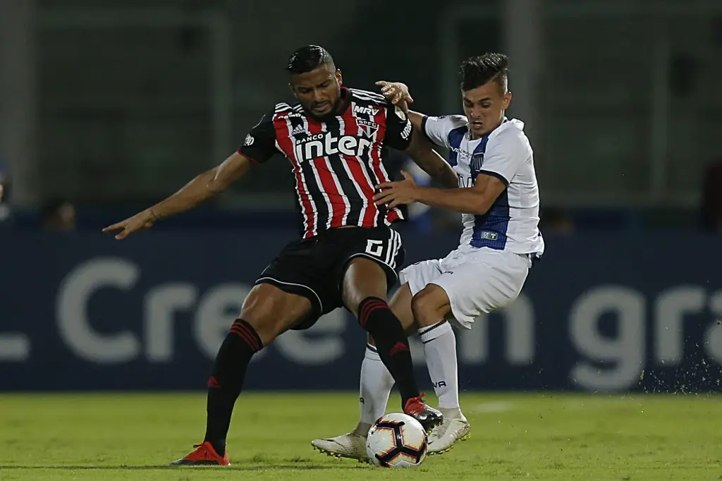 Brazil's Sao Paulo FC defender Reinaldo (L) vies for the ball with Argentina's Talleres midfielder Andres Cubas during their Copa Libertadores football match at Mario Alberto Kempes Stadium in Cordoba, Argentina on February 6, 2019. (Photo by DIEGO LIMA / AFP)