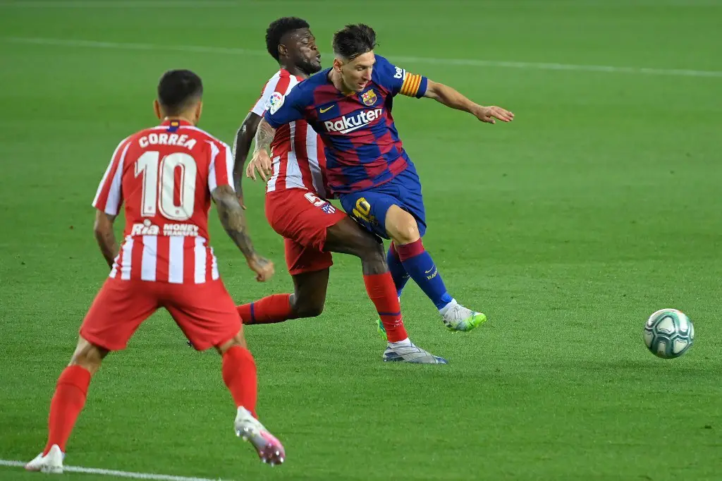 Barcelona's Argentine forward Lionel Messi (R) challenges Atletico Madrid's Ghanaian midfielder Thomas Partey and Atletico Madrid's Argentine forward Angel Correa (L) during the Spanish League football match between FC Barcelona and Club Atletico de Madrid at the Camp Nou stadium in Barcelona on June 30, 2020. (Photo by Lluis GENE / AFP)