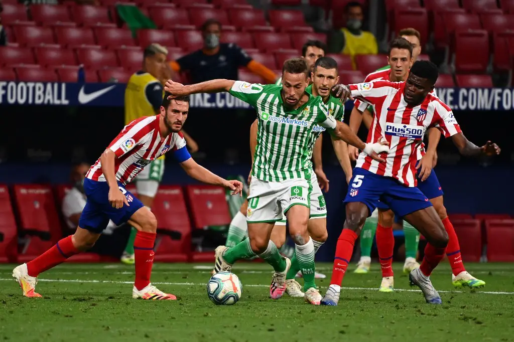 Real Betis' Spanish midfielder Sergio Canales (C) vies with Atletico Madrid's Ghanaian midfielder Thomas Partey (R) during the Spanish league football match between Club Atletico de Madrid and Real Betis at the Wanda Metropolitano stadium in Madrid on July 11, 2020. (Photo by GABRIEL BOUYS / AFP)