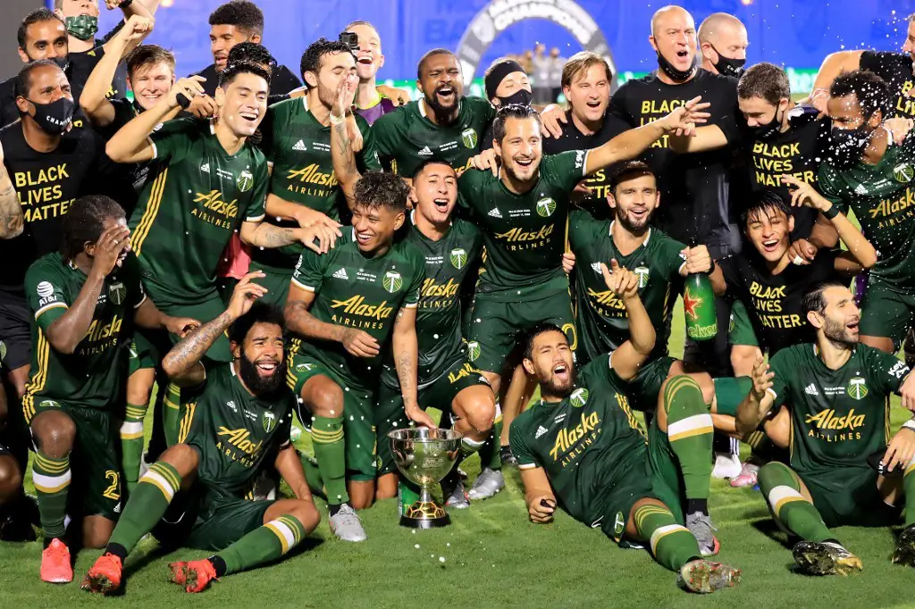 REUNION, FLORIDA - AUGUST 11: Players of Portland Timbers celebrate with the champions trophy after defeating Orlando City 2-1 in the final match of MLS Is Back Tournament at ESPN Wide World of Sports Complex on August 11, 2020 in Reunion, Florida.   Sam Greenwood/Getty Images/AFP