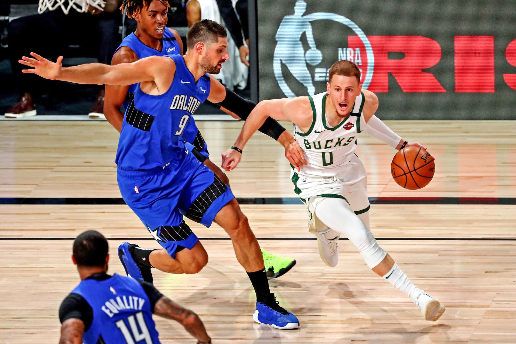 Aug 29, 2020; Lake Buena Vista, Florida, USA; Milwaukee Bucks guard Donte DiVincenzo (0) drives to the basket against Orlando Magic center Nikola Vucevic (9) during the first quarter in game five of the first round of the 2020 NBA Playoffs at AdventHealth Arena. Mandatory Credit: Kim Klement-USA TODAY Sports/Sipa USA 
Photo by Icon Sport - ESPN World Wide of Sports Complex - Orlando (Etats Unis)