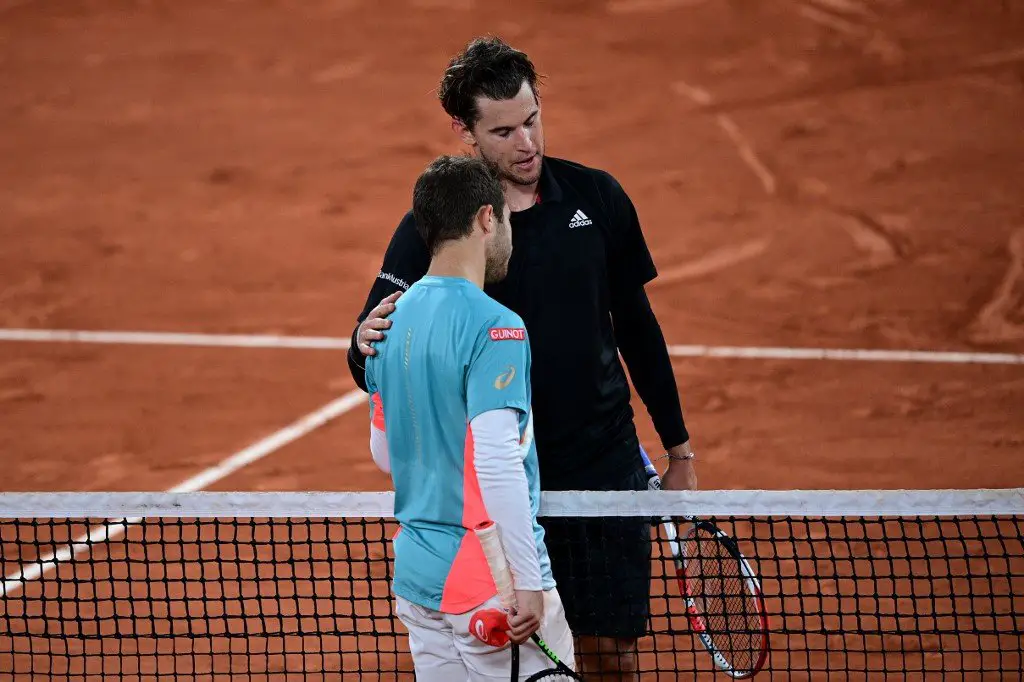 Winner Austria's Dominic Thiem (R) congratulates France's Hugo Gaston at the end of their men's singles fourth round tennis match on Day 8 of The Roland Garros 2020 French Open tennis tournament in Paris on October 4, 2020. (Photo by MARTIN BUREAU / AFP)