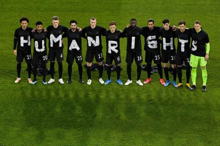 The players of the German national team stand together and form the lettering "Human Rights"