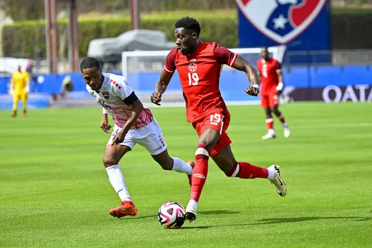 Mar 23, 2024; Frisco, Texas, USA; Canada midfielder Alphonso Davies (19) moves the ball past Trinidad and Tobago defender Shannon Gomez (14) during the first half at Toyota Stadium. Mandatory Credit: Jerome Miron-USA TODAY Sports/Sipa USA   - Photo by Icon Sport